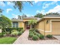 Inviting front entrance with a brick pathway and well-maintained landscaping leading to a red front door at 1195 Legendary, Clermont, FL 34711