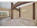 Spacious living room with a chandelier, large window, stylish pillars, and neutral color palette at 1195 Legendary, Clermont, FL 34711