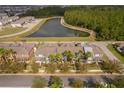 Aerial view of townhomes near a pond and lush greenery, showcasing community layout and natural surroundings at 14849 Driftwater Dr, Winter Garden, FL 34787