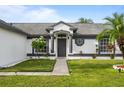 Inviting home entrance with landscaped yard and decorative architectural details at 14923 Day Lily Ct, Orlando, FL 32824