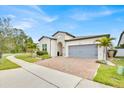 Charming one-story home features a brick driveway, attached garage, and lush tropical landscaping at 2117 Trani Ter, St Cloud, FL 34771