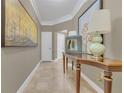 Elegant hallway with a console table, artwork, neutral walls and tile floors at 2305 Edgewater Dr # 1701, Orlando, FL 32804