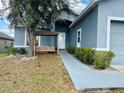 Charming home featuring an inviting porch swing with a sidewalk leading to the front door at 233 Ashley Loop, Davenport, FL 33837