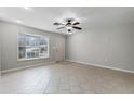 Spacious living room featuring neutral walls, tile flooring, a ceiling fan, and a large bay window at 250 Douglas Dr, Eustis, FL 32726