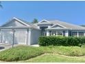 Attractive one-story home with a well maintained lawn, two car garage and trimmed bushes at 2628 Caribe Dr, The Villages, FL 32162