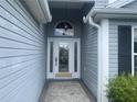 Elegant front door featuring glass panels, a decorative window, and a brick walkway at 2628 Caribe Dr, The Villages, FL 32162