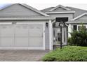 Charming single Gathering home featuring attached garage, paved driveway, and beautifully landscaped front entrance at 2628 Caribe Dr, The Villages, FL 32162