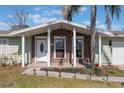 Inviting front porch with brick facade, white columns, and stylish front door at 2662 Hibiscus Ct, Deltona, FL 32738