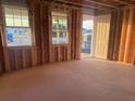 Unfinished room with exposed wood framing, windows, and a view of the outdoors, ready for customization at 30117 Misty Pines Rd, Mount Dora, FL 32757