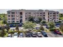 Exterior angle shot showcasing the condo building with a well-maintained parking lot and landscaping on a sunny day at 3177 Feltrim Pl # 304, Kissimmee, FL 34747