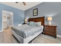 Comfortable main bedroom with a large bed, wood furniture, and ensuite bathroom, and light blue walls at 3204 Gold Ln, Kissimmee, FL 34747