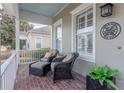 Cozy front porch with comfortable chairs, brick flooring, and view of the neighborhood at 4268 Ethan Ln, Orlando, FL 32814