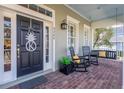 Inviting front porch featuring rocking chairs, swing, decorative door and brick flooring at 4268 Ethan Ln, Orlando, FL 32814