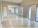 Bright and airy living room with neutral tile flooring and an open floor plan to the kitchen at 4439 Pinebark Ave # 47-4, Orlando, FL 32811