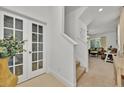 Bright foyer featuring a staircase, tile flooring, and a decorative glass door leading to an office space at 5237 Royal Point Ave, Kissimmee, FL 34746