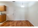 Dining area featuring hardwood floors and overhead light fixture next to an open door at 5550 E Michigan St # 3309, Orlando, FL 32822