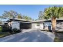 Modern garage with a dark door, clean white siding, and a freshly paved driveway at 605 Hill Ave, Ocoee, FL 34761