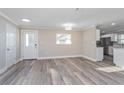 Bright living room featuring new hard surface flooring, a window, and a glass door to the exterior at 605 Hill Ave, Ocoee, FL 34761