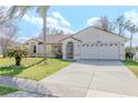 Inviting home featuring a long driveway, well-kept lawn, and a classic design for comfortable suburban living at 6385 Royal Tern St, Orlando, FL 32810