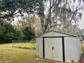 Large, metal outdoor shed with double doors provides extra storage space at 701 S Delaware Ave, Deland, FL 32720