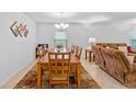 Open-concept dining room with a wooden table set and view into the living space at 921 Emerald Green Ct, Kissimmee, FL 34746