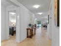 Inviting hallway with neutral tile flooring leading to a bedroom and open-concept living area at 921 Emerald Green Ct, Kissimmee, FL 34746