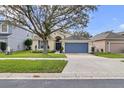 Single-Gathering home featuring a well-maintained lawn and a blue two-car garage at 10286 Cypress Knee Cir, Orlando, FL 32825