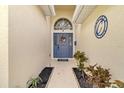 Inviting front entrance with a stylish blue door, decorative wreath and beautiful landscaping at 10286 Cypress Knee Cir, Orlando, FL 32825