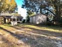 Large backyard featuring a shed, well and lush trees, offering a serene outdoor space at 12314 Virginia Dr, Leesburg, FL 34788