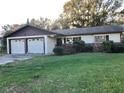 Charming single-story home with an attached two-car garage and a well-manicured lawn at 12314 Virginia Dr, Leesburg, FL 34788