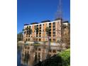 Waterfront condominium building featuring multi-story balconies and lush landscaping at 12521 Floridays Resort Dr # 206F, Orlando, FL 32821