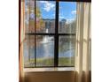 View of a decorative fountain and condo complex reflected from a window showing trees and blue skies at 12521 Floridays Resort Dr # 206F, Orlando, FL 32821