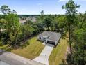 Aerial view of a modern one-story home with a well-manicured lawn and mature trees at 13817 Sw 43Rd Cir, Ocala, FL 34473