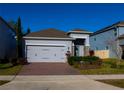 Inviting single-Gathering home with a brick driveway, two-car garage, and well-manicured front yard at 1740 Deans Crossing Ln, Orlando, FL 32825