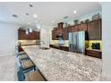 Spacious kitchen island with granite countertops, seating, and pendant lighting above at 209 Silver Maple Rd, Groveland, FL 34736