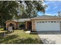 Charming single-story home featuring a well-maintained lawn and an attached two-car garage at 231 Cranbrook Dr, Kissimmee, FL 34758