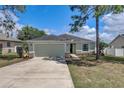 Well-maintained home featuring a two-car garage, stone accents, and a neatly landscaped front yard at 2604 Hollow Ln, Leesburg, FL 34748