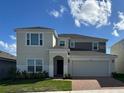 Two-story home featuring a two-car garage, neutral colors, and a well-manicured lawn at 4229 Deleon St, Haines City, FL 33844