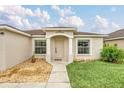 Inviting front entrance features decorative columns and a meticulously kept lawn at 445 Peter Pan Blvd, Davenport, FL 33837