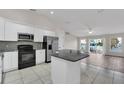 Modern kitchen with stainless steel appliances, granite countertops, and a view to the patio at 445 Peter Pan Blvd, Davenport, FL 33837