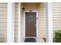 Close-up of a brown front door with white trim and pillars, featuring a modern lock and the unit number at 5356 Diplomat Ct # 105, Kissimmee, FL 34746