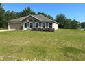 Single-story home showcases a well-maintained lawn, attached garage, and a charming front facade at 6743 Sw 129Th St, Ocala, FL 34473