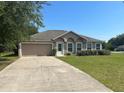 Charming single-story home boasts a well-manicured lawn, attached garage, and a welcoming front entrance at 6743 Sw 129Th St, Ocala, FL 34473