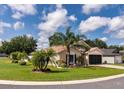 Beautiful single-story home with lush green lawn, tropical landscaping, and a two-car garage at 730 Garberia Dr, Davenport, FL 33837