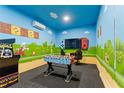 Bright game room featuring custom Super Mario themed wall murals, foosball table, and arcade game at 8900 Candy Palm Rd, Kissimmee, FL 34747