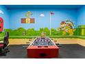 Spacious game room featuring foosball table, themed murals, and gaming setup at 8900 Candy Palm Rd, Kissimmee, FL 34747