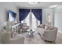 Sophisticated living room with elegant furnishings, featuring large front window with dark curtains at 9918 Pallida Hickory Way, Winter Garden, FL 34787