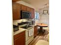 Bright kitchen with wood cabinets, modern appliances, a round wood table, and wood-look floors at 1011 Piedmont Oaks Dr, Apopka, FL 32703
