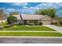 Inviting single-story home featuring a lush green lawn and mature landscaping in a sunny neighborhood at 105 Lena Ann Dr, St Cloud, FL 34771