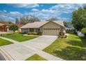 Well-maintained home with a verdant front lawn, mature shrubbery, and a convenient two-car garage at 105 Lena Ann Dr, St Cloud, FL 34771